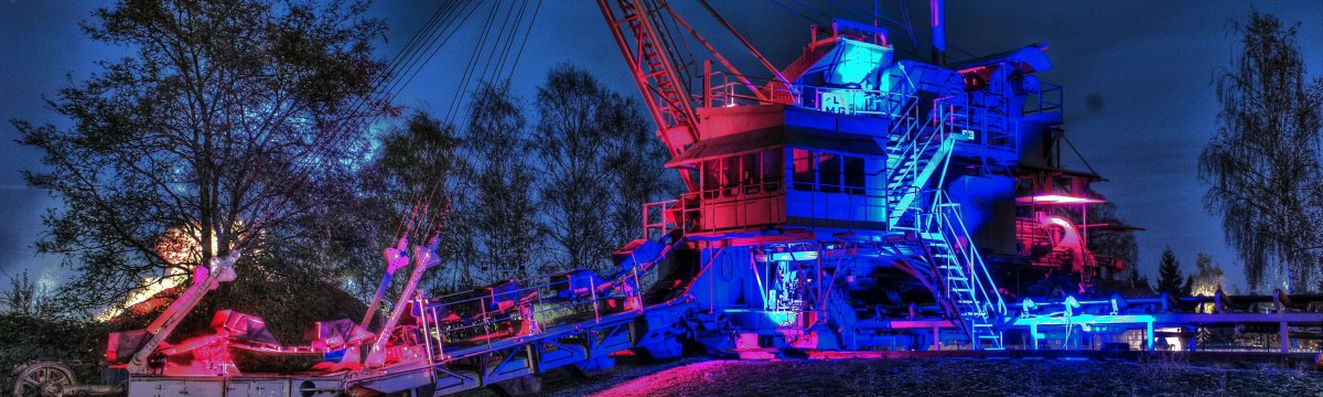 Industriekultur bei Nacht. Die Bergbaubagger des Freilichtmuseums werden kunstvoll illuminiert und bilden eine tolle Kulisse für die Aktionen.